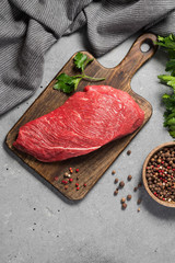 Raw beef meat on a wooden Board on a gray kitchen table