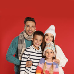 Fototapeta na wymiar Happy family in warm clothes on red background. Winter season
