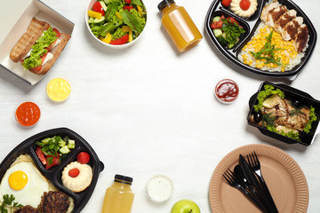 Frame made of lunchboxes on white table, top view with space for text. Healthy food delivery