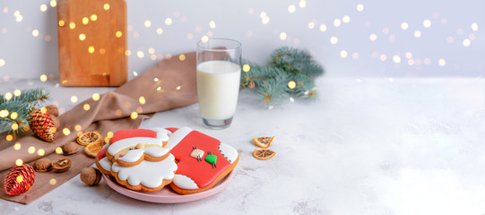Plate with tasty Christmas cookies and glass of milk on table