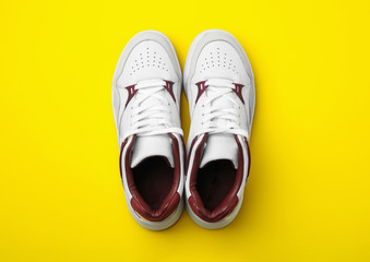 Pair of stylish shoes on yellow background, top view