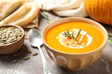 Delicious pumpkin soup in bowl on marble table