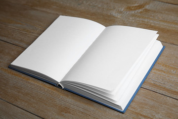 Fototapeta premium Open book on wooden table. Space for text