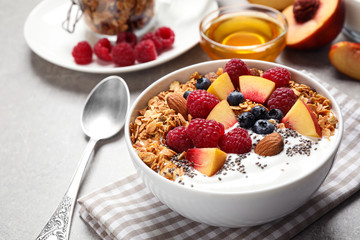 Tasty homemade granola with yogurt served on grey table. Healthy breakfast - Powered by Adobe