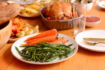Plate with roasted vegetables served on table for big family dinner