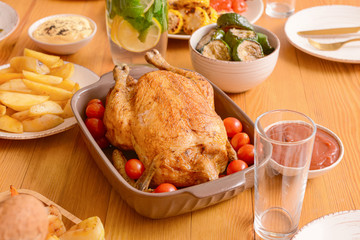 Baking dish with tasty chicken and tomatoes on served table