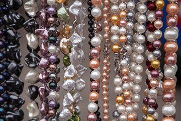 Various colorful beads in the market. Wallpaper background of a colorful necklace made of precious stones and colored beads.