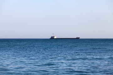 Black Sea. Dry cargo ship on the horizon. The weather is clear. The sea is blue.