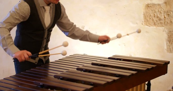 Man Playing the marimba in a medieval french monastery. beautiful close shot of a body playing music sound in traditional french old church