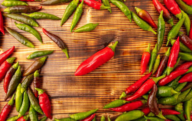 Green and red chili peppers on a wooden board