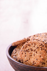 Cookies of sesame seeds, sunflower seeds and other spices on a wooden plate. Bright key