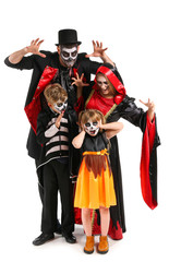 Family in Halloween costumes on white background