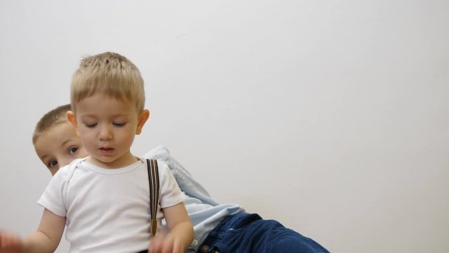 Children playing, big brother hiding behind little brother