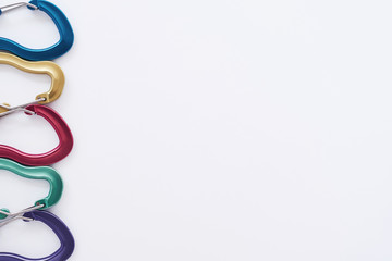 Left side of the pcture. Many of the multi colored carabiners on lying on the white table