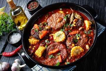 Burgers in marinara sauce with corn cobs