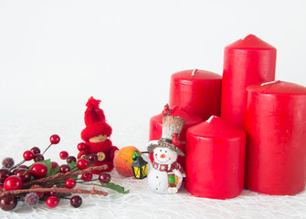 Red candles and Christmas toys with a branch of berries