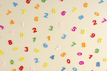 Colored wooden numbers composition on beige background.