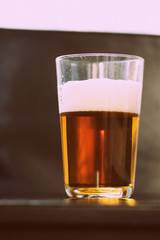 Glass with a light beer closeup in retro style