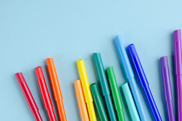 Colored felt tip pens composition on blue background.