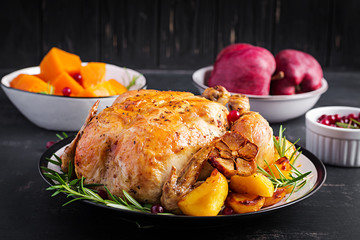 Baked turkey or chicken. The Christmas table is served with a turkey, decorated with bright tinsel. Fried chicken, table setting. Christmas dinner.