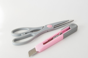 Gray scissors and a stationery knife