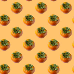 Seamless pattern with fresh persimmon fruit on a light orange color background. Modern style isometric concept