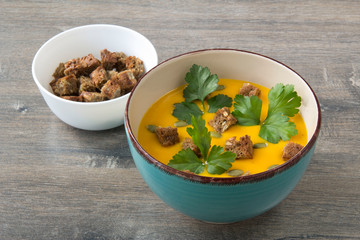 Pumpkin cream soup with pumpkin seeds and parsley