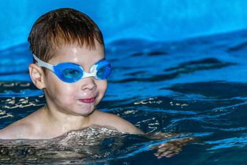 Naklejka premium boy in swimming pool wearing swimming goggles