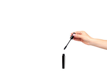 Hand with black mascara, eye makeup brush.