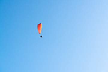 orange paracute in blue sky