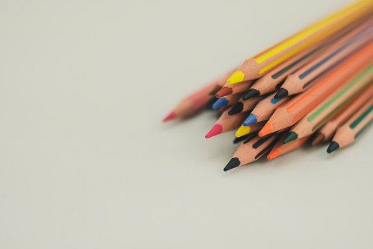 Colored pencils appear from the top right on a white background