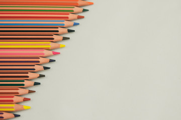 Lápices de colores desde la izquierda, bien afilados, sobre fondo blanco y alineados en escalera