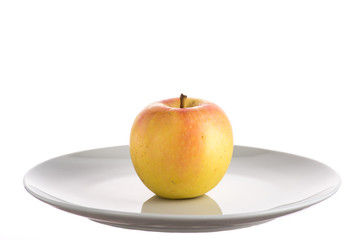 red and yellow apple on a white plate on a white background