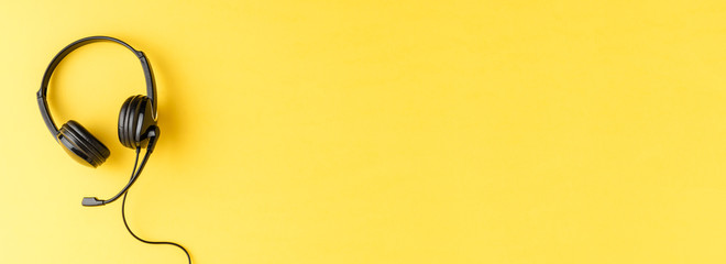 Helpdesk headphones on yellow background with copyspace. Banner