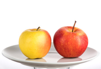 red and yellow apple on a white plate on a white background