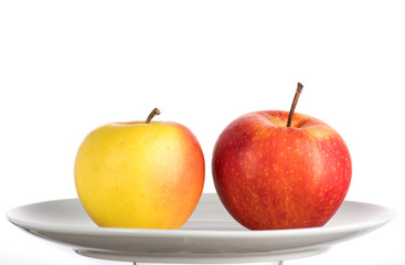 red and yellow apple on a white plate on a white background