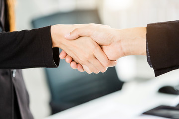 businesswoman and businessman shaking hands at In the office room background after the contract is signed or handshake greeting deal,business expressed confidence embolden and successful concept © Thinapob