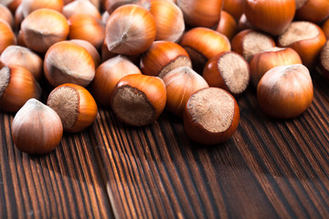 close up of hazelnuts on wooden table .