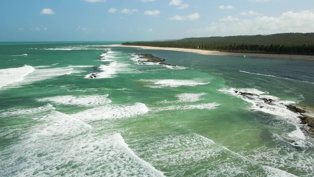 This is the beach of Gunga, in Brazil. 
There is a rock formation that stops the waves from coming to the beach.