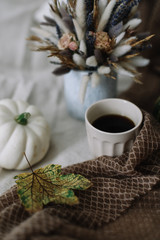 Coffee cup with flowers and pumpkins on a cozy plaid. Autumn still life. Breakfast in bed. Good morning. Stylish autumn flat lay. 