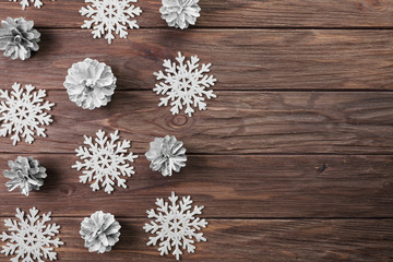 Paper snowflakes and snags on wooden board