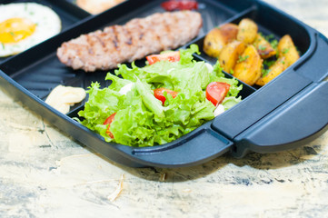 Breakfast, fried steak or cutlet, salad with tomato and green vegetables, toast, potato, egg closeup, light background. Concept healthy eating, diet, menu, nutritious food.