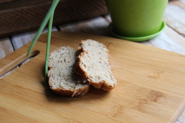 Gray grain bread slices close up on wooden cutting board