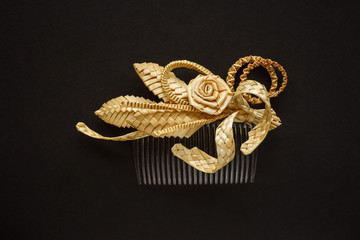 Fototapeta premium Ornamental hair comb with straw flowers on a dark background