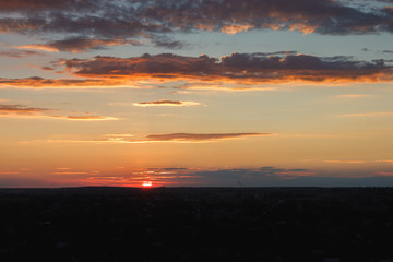 Colorful sunset. Clouds in the evening sky. View from the roof of a multistory building. Ukraine