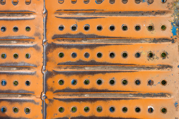 Metallic texture with perforation, rust and painted orange. Military background