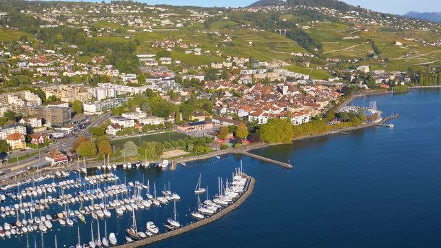 Helicopter aerial shot over Lutry harbour and medieval town. Autumn sunset colors. Lavaux, Switzerland