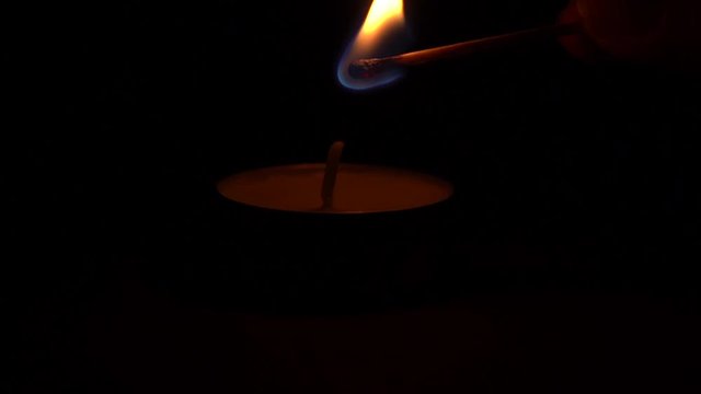 Lighting a candle with match in the darkness