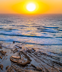 People walking on the beach at sunset