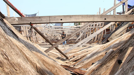 Timber shipbuilder working while working at a shipyard, Batang Indonesia,